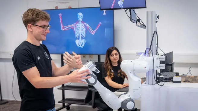 Researchers at the Munich Institute for Robotics and Machine Intelligence work with a robotic arm.