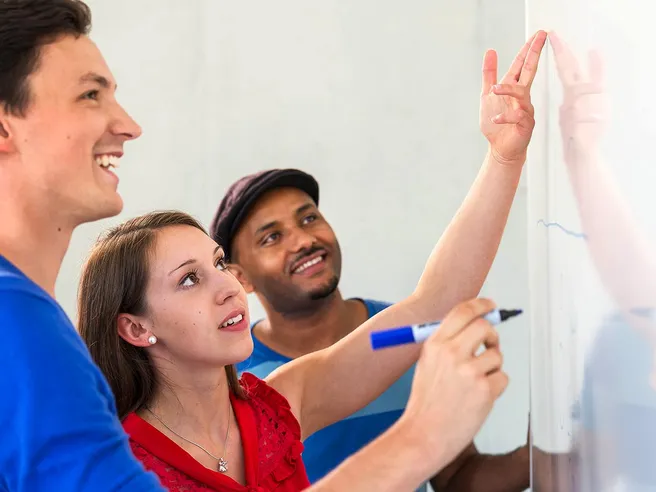 Drei Studierende am Whiteboard