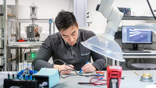 Wissenschaftler beim Löten einer Ansteuerplatine für Hochfrequenzschalter