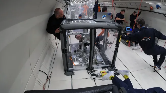 0g experiment performed during the RoboGrav mission with safety operator Markus Grebenstein (DLR, left) and Maximilian Mühlbauer (TUM, behind a rack) interacting with the robot through a rope.