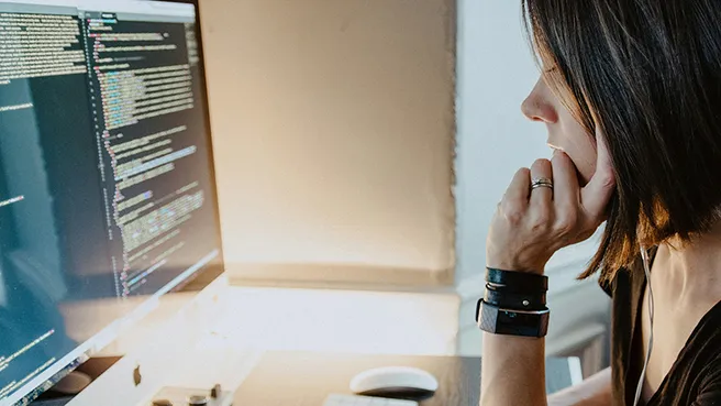 Woman at computer with code