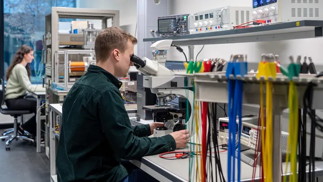 Student examines samples with a microscope to check and document manufacturing quality.